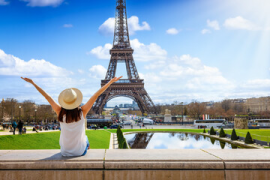 A tourist woman enjoys the beautiful view of the Eiffel Tower in Paris, France, during a sunny spring day.png
